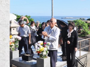 慰霊碑前で犠牲者の冥福を祈る遺族ら＝２３日、徳之島町
