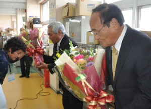 職員から花束を受け取る（手前右から）南町長と川上副町長＝２４日、与論町役場