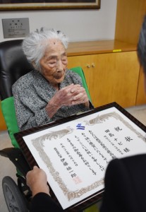 県内最高齢の祝い状を受け取る田島ナビさん＝１５日、喜界町赤連の喜界園