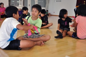 バンダナを使って応急処置を練習する子どもたち＝８月３０日、和泊町のやすらぎ館