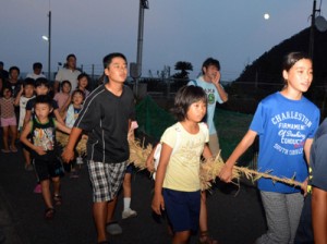 大綱を引いて「十五夜どー、十五夜どー」の掛け声で集落を練り歩く子どもたち＝２７日、奄美市名瀬小湊