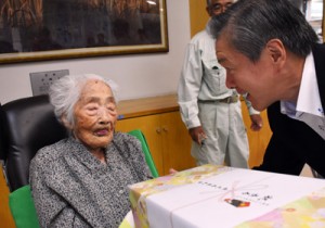 記念品を受け取る田島さん（左）＝１５日、喜界町赤連の喜界園