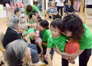 風船遊びなどでお年寄りと触れ合った「赤ちゃん先生」とママ講師たち＝２３日、奄美市名瀬