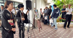 島唄で国文祭参加者らを歓迎する岩元梨恵さん、中村瑞希さん（左から）＝３０日、奄美空港