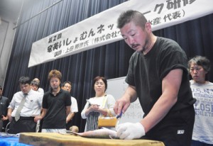 魚食普及について講話し、活け締めの実演も行った上田さん＝７日、奄美市名瀬