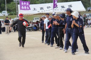 ボールを抱え疾走する仲間に声援を送るチーム＝２０日、喜界町総合グラウンド