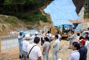 砂防ダムの工事現場で赤土流出防止対策を確認する参加者＝２１日、奄美市笠利町手花部