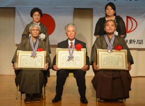 南海文化賞を受賞した（前列左から）弓削氏、油井豊年踊り保存会の内田会長、興氏。（後列左から）弓削氏の妻・瑞子さん、興氏の妻・美代子さん＝２日、奄美市名瀬