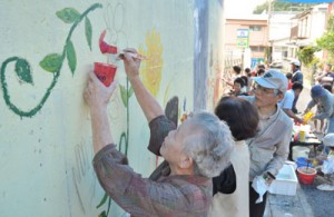 壁面に思い思いに絵を描く参加者＝２１日、奄美市名瀬矢之脇町