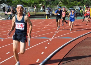 熱戦を展開した男子年齢別８００㍍リレー＝１５日、奄美市名瀬運動公園陸上競技場