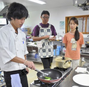 料理の手本を見せる南舘さん（左）＝１２日、与論町のゆんぬ体験館 