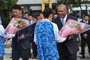 歓迎の花束を受け取るラミレス監督（右）と梶谷隆幸選手＝５日、奄美空港