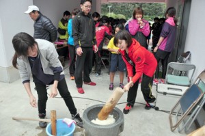 餅つきを楽しむ選手ら＝２９日、名瀬運動公園陸上競技場