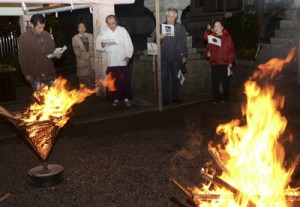 日の丸の小旗を振り、復帰の歌を合唱する参加者＝２５日、奄美市