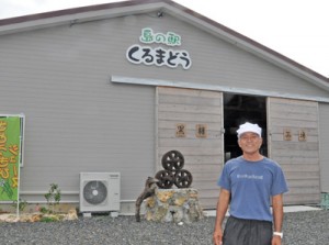 オープンした「島の駅くるまどう」と鬼塚社長＝２２日、与論町麦屋