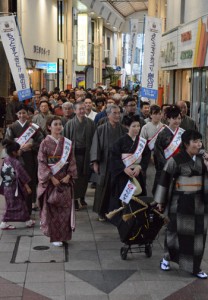 紬姿でアーケード街を練り歩く参加者＝５日、奄美市名瀬