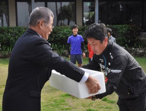 冬季合宿中の実業団にカンパチを贈った奄美群島地区漁業士会の茂野拓真会長（左）＝１０日、天城町