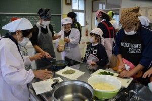 講師の手ほどきを受けながら油ぞうめんを作る崎原小中学校の児童、生徒たち＝２２日、奄美市の崎原小中学校