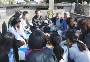 墓前で先祖と共に新年を祝う一族＝１６日、知名町田皆