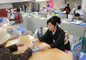 大島紬姿で接客に当たる女性職員＝４日、奄美市