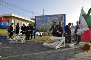 愛称「えらぶゆりの島空港」をＰＲする看板を除幕する関係者＝１３日、沖永良部空港