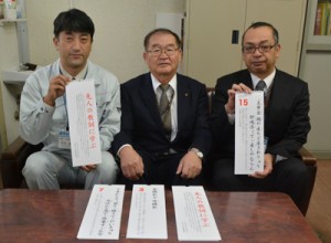 大和村教委と村ＰＴＡ連絡協議会が作成した島口教訓カレンダー。（右から）和泉豊一社会教育係長、藤井俊郎教育長、政村勇二会長＝１６日、同村役場