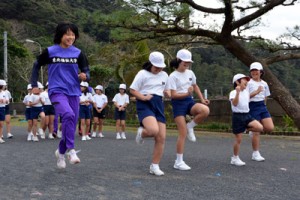 もも上げなどの基礎トレーニングを学生に教わった児童たち＝２２日、宇検村立田検小学校