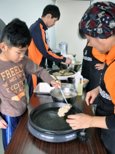 ジャガイモお焼き作りに挑戦する参加者＝２７日、和泊町の実験農場