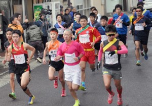 沖永良部島内一周駅伝のスタート。勢いよく走りだす１区の選手＝７日、和泊町役場前