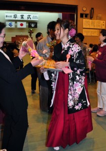 花束で祝福を受ける卒業生たち＝１日、奄美高校