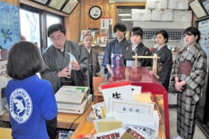 水産物販売所を訪問し、商品の宣伝方法などについて職員らと共に考えた学生ら＝奄美市笠利町
