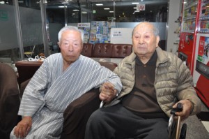 ７０年ぶりの再会を果たした久保さん（右）と高國さん＝１５日夜、奄美市名瀬