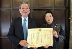 表彰式に出席した吉田茂子会長（右）と、受賞の報告を受けた金子万寿夫衆院議員（鹿児島県東京事務所提供）