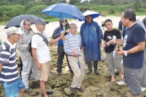 土盛海岸であった微生物岩の現地説明会。中央が中森亨准教授＝２４日、奄美市笠利町 