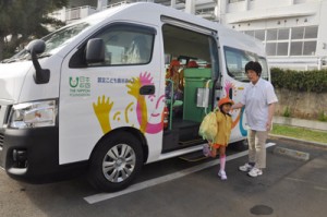 真新しい送迎バスを降りて登園する園児＝７日、知名町田皆