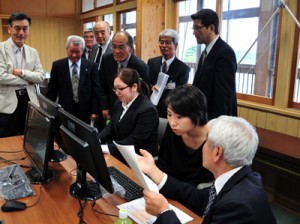 開所式で業務のデモンストレーションを見学する出席者ら＝５日、喜界町 