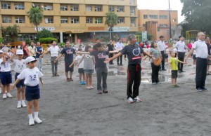 早朝のラジオ体操で汗を流す参加者＝２５日、奄美市名瀬