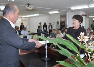 福山副市長から委嘱状を受け取る推進員（右）＝１２日、奄美市役所