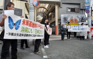 横断幕を掲げて事件に抗議する参加者＝２７日、奄美市