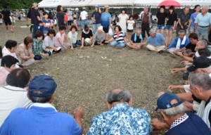 八月踊り唄に合わせて行った石打ち遊び（上）。老若男女が参加して先人たちの暮らしに思いをはせた＝２６日、龍郷町戸口 　