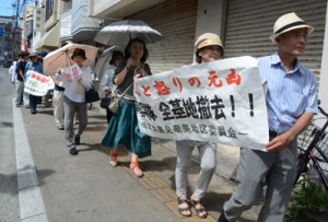 「沖縄の悲劇を終わらせよ」―。シュプレヒコールを上げてデモ行進する市民集会の参加者たち＝１９日、奄美市名瀬