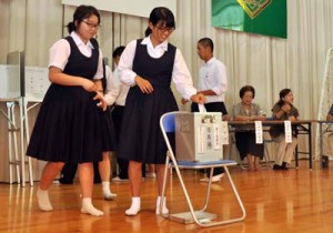 模擬投票で意中の候補に一票を投じる生徒＝２日、奄美市名瀬の県立大島高校