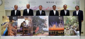 「あまみっけ。」のポスターを喜ぶ奄美大島５市町村長ら＝１日、奄美市名瀬