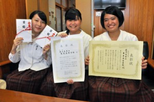 ダブル受賞を報告する（左から）山田愛さん、川村あみさん、福島珠緒さん＝２９日、奄美高校