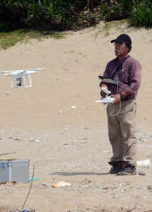 ドローンを飛ばして上空からの撮影に取り掛かる西教授＝１日、龍郷町赤尾木