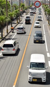 街中を行き交う車両。保有車両は年々増えている＝６月３０日、奄美市名瀬塩浜町