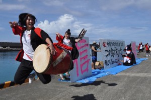 知名町制施行７０周年記念のパフォーマンスを繰り広げる沖永良部高校のエイサー部と書道部＝３１日、知名町の知名漁港