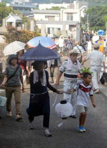 ちょうちんを手に墓参し、先祖の霊を送る人々＝１７日、奄美市名瀬の永田墓地