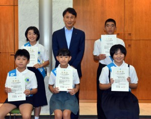 任命証を手に撮影するかごしまこども環境大臣（前列右が德重さん、後列左が鬼塚さん）＝５日、鹿児島市の県庁