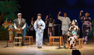 「渡しゃ」を歌った松山美枝子さん（前列中央）。子どもたちの八月踊りが祭り気分を演出した＝４日、奄美文化センター